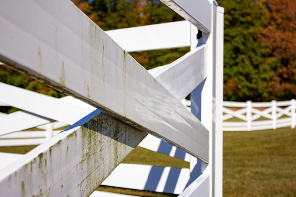 Vinyl fence that has undergone a partial fence power washing. The photo shows portions cleaned and not cleaned to display the vast difference.