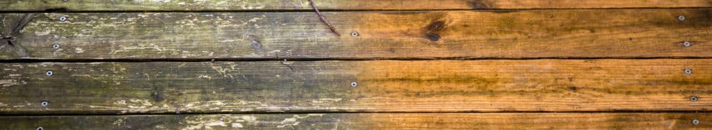Dirty wooden deck floor next to freshly cleaned wooden deck floor to show results of power washing