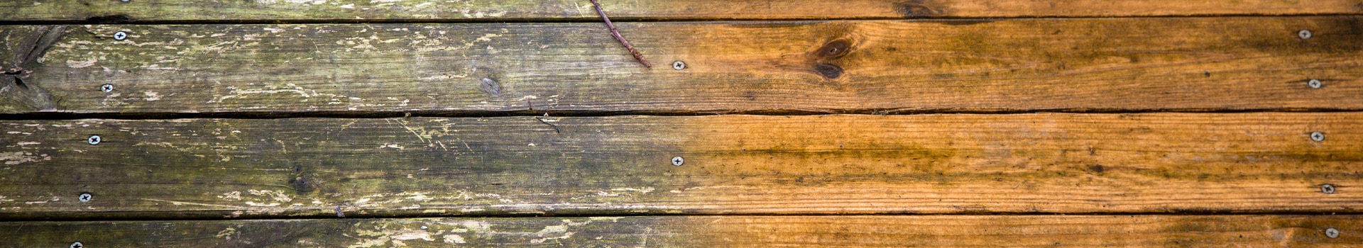Dirty wooden deck floor next to freshly cleaned wooden deck floor to show results of power washing