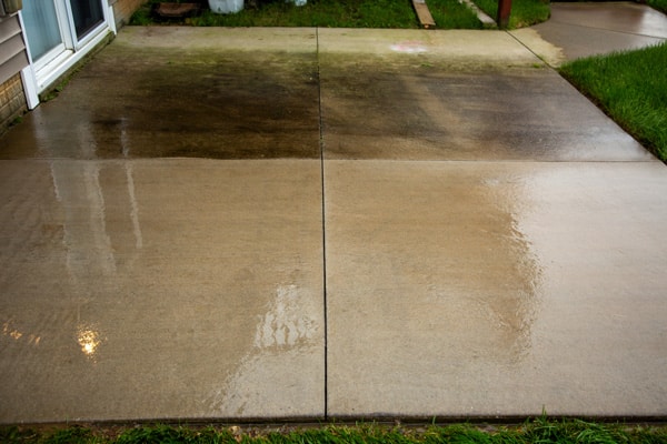 Before and after patio power washing. Top portion shows dirty concrete patio, lower portion shows perfectly clean concrete patio.