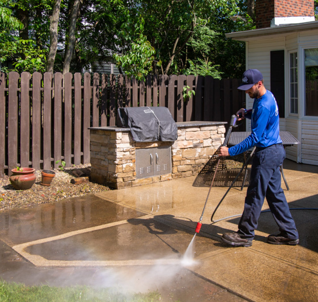 Hydro Savage Pressure Washing technician power washing concrete patio