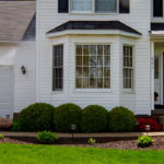 Power washing technician washing vinyl siding. Washing your siding is recommended when you move into a new house.