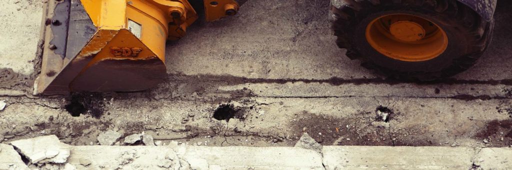 Construction equipment being used to smooth and repair a concrete surface